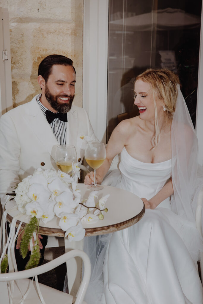 Moments éditoriaux et fun des mariés sous la pluie à Bordeaux, entre dégustation de baguette et baiser spontané.